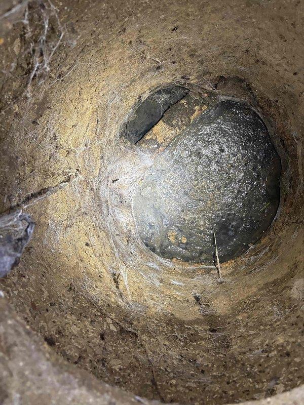 Conducted on-site assessment for galvanized pipe replacement in residential property. Inspected underground plumbing infrastructure including accessible utility chamber and interior bathroom plumbing connections. Documented existing galvanized piping conditions, photographed underground access point showing aged concrete infrastructure, and evaluated bathroom fixture connections at toilet and vanity locations to determine scope of pipe replacement work required for estimate preparation.