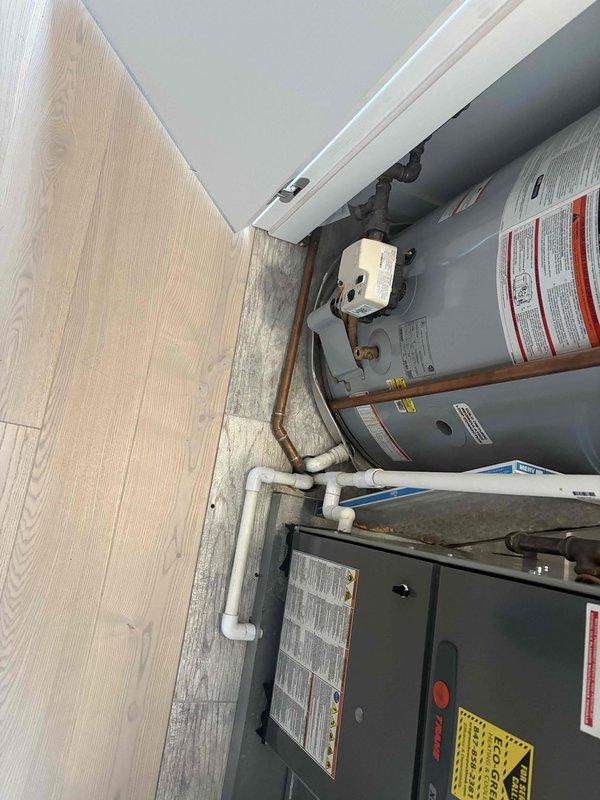 Conducted on-site evaluation of dual water heater system in residential utility closet to provide replacement estimate as requested. Inspected existing gray cylindrical water heaters with connected copper and PVC plumbing lines, condensate pump installation, and overall mechanical room configuration. Documented current system condition through photography and assessed replacement requirements. Additionally evaluated sink handle for separate replacement quote as specified in service request.