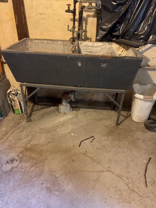 Responded to a clogged utility sink in the basement that was receiving drainage from the kitchen sink above but failing to drain properly. Inspected the drainage system and determined the blockage was isolated to the utility sink drain line, which was not yet affecting the kitchen sink function. Cleared the obstruction from the drain line using appropriate drain cleaning equipment, restored proper water flow through the utility sink, and verified that drainage from both the utility sink and kitchen sink was functioning correctly.