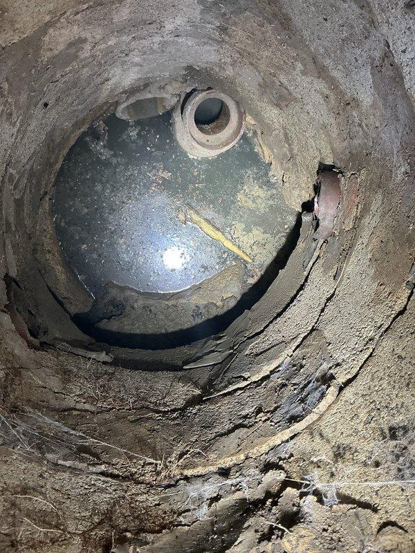Responded to water leak concern related to catch basin. Performed inspection of basement utility area and underground catch basin structure. Documented existing conditions including concrete deterioration, visible cracking in basin walls, and moisture indicators. Assessed pressure tank installation within cylindrical concrete pit, noting age-related wear and potential structural compromise of surrounding containment area. Provided customer with repair and replacement options for catch basin system to address leak source and prevent further water intrusion.