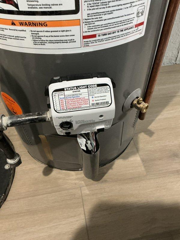 Responded to service call for grinding noise coming from recently installed Rheem Performance Plus tanked water heater. Upon arrival, inspected unit and confirmed hot water production was still operational. Performed diagnostic assessment of gas control valve, burner assembly, and internal components to identify source of grinding noise. Documented water heater condition with photos showing gas control valve with status light indicators, copper supply lines, brass fittings, and proper venting configuration. Unit appears properly installed with adequate clearances and professional plumbing connections.