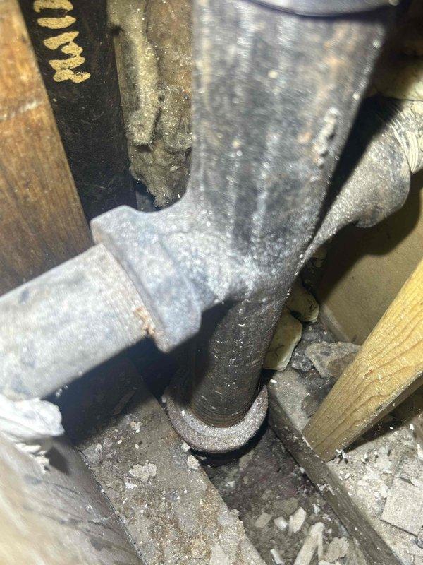 Completed initial drain and sewer assessment for commercial facility. Inspected bathroom sink line experiencing drainage issues and documented existing conditions in confined mechanical space. Photographed heavily dust-covered plumbing components, including vertical pipe runs with significant debris accumulation and aged metal fittings showing wear. Identified need for excavation and repair of bathroom sink line. Follow-up estimate scheduled for excavation scope and line repair recommendations.