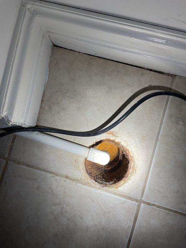 Responded to commercial facility reporting persistent odor in bathroom. Upon investigation, identified significant corrosion and rust staining around floor drain opening beneath jetted bathtub installation. The deterioration of the drain assembly and surrounding floor penetration was determined to be the likely source of the sewer gas odor infiltrating the bathroom space. Documented conditions with photographic evidence showing extensive oxidation around the drain fitting and compromised seal at the floor interface. Provided estimate for drain assembly replacement and proper sealing to eliminate odor issue and prevent further water damage to subfloor.