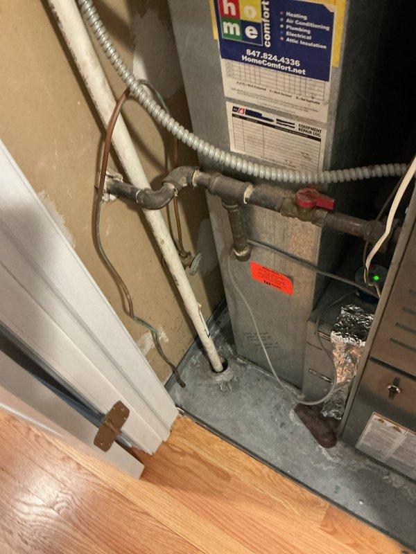Responded to a clogged upstairs drain that was identified during routine HVAC maintenance by another contractor. Upon arrival, inspected the plumbing system in the utility area where washing machines and laundry fixtures are located. Assessed the drainage issue and documented the existing plumbing configuration, including exposed PVC drain lines and connections in the mechanical/laundry room area.