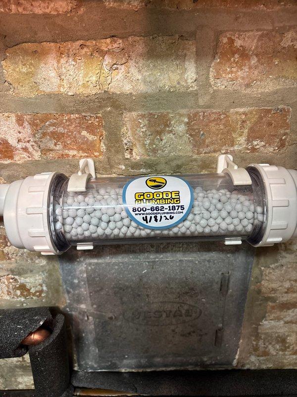 Completed warranty service by installing water treatment filtration system with polyphosphate media for scale prevention. Installed unit on basement wall near existing plumbing infrastructure and verified proper integration with under-sink copper supply lines and shut-off valves. System is operational and providing water conditioning to kitchen fixtures.