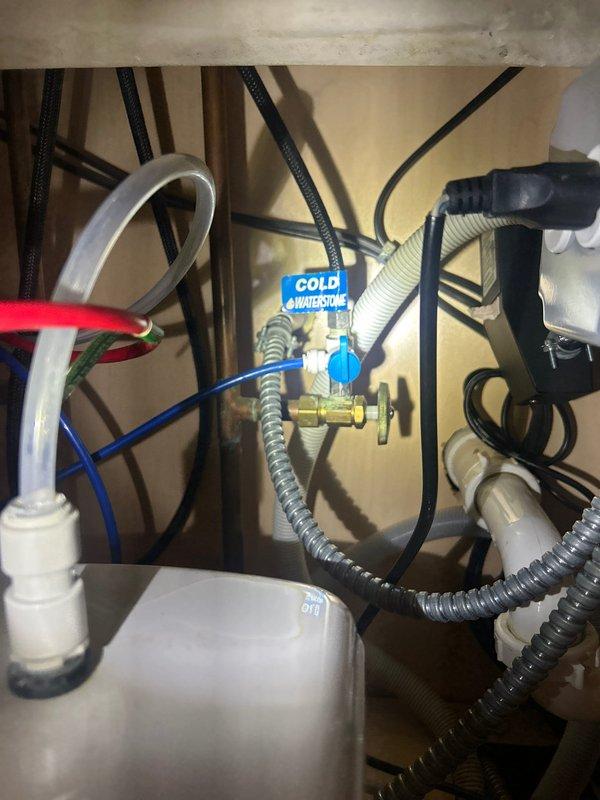 Responded to service call for reported water heater leak located under sink. Upon arrival, performed thorough inspection of under-sink plumbing assembly including water heater connections, supply lines, shut-off valves, and associated flex hoses. Examined brass fittings, braided stainless steel flexible connectors, and corrugated hot and cold water supply lines for signs of moisture, corrosion, or active leaking. Inspected connection points between water heater unit and distribution system, verifying integrity of all compression fittings and threaded connections. Documented existing plumbing configuration with photographic evidence showing complete under-cabinet assembly including shut-off valves with identification tags, multiple flexible supply lines, and mounting hardware. Provided estimate for necessary repairs to resolve ongoing leak issue.