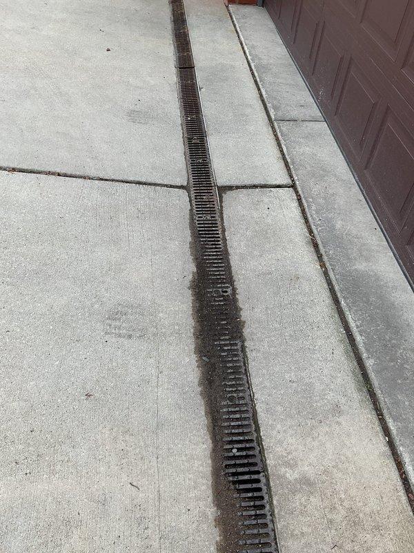 Inspected and cleaned trench drain system running along commercial building exterior and patio area. Trench drain was successfully cleared of debris and verified to be flowing properly. Scheduled follow-up service with vector truck to perform hydro-jetting and rodding of connected storm basin to ensure complete drainage system functionality.