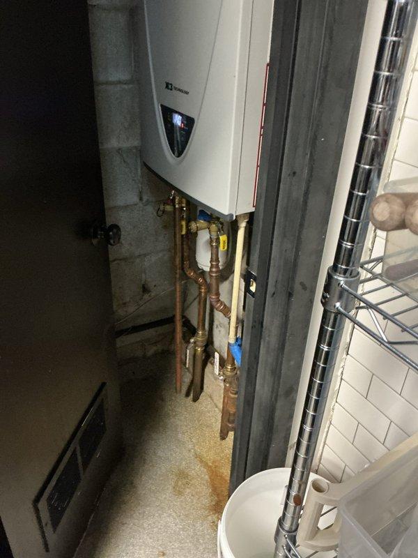 Performed descaling maintenance service on an A.O. Smith tankless water heater unit. Flushed the heat exchanger using descaling solution to remove mineral buildup and restore optimal heating efficiency. Inspected all copper supply lines, brass isolation valves, and plumbing connections for proper operation and verified system functionality upon completion.