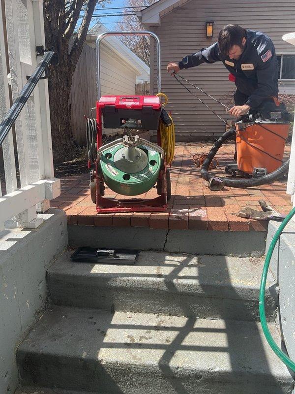 Responded to a clogged outdoor floor drain that had recently developed slow drainage issues with visible sludge accumulation. Utilized mechanical drain cleaning equipment to clear the blockage and restore proper water flow. Recommended future camera inspection to assess potential tree root intrusion based on neighboring property history with similar issues.