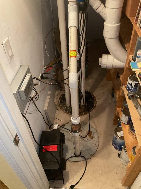 Responded to customer complaint of noisy sump pump operation in 20-year-old residential property. Upon arrival, conducted thorough inspection of sump pump system, discharge piping, and associated electrical components in basement utility area. Assessed pump motor, float switch mechanism, and check valve for proper operation and signs of wear. Examined PVC discharge lines, fittings, and connections for secure mounting and potential sources of vibration or water hammer. Verified electrical connections at control panel and pump unit were secure and functioning within normal parameters. Identified source of noise and provided customer with findings and recommendations for resolution. Documented system condition with photographic evidence showing plumbing configuration, electrical controls, and overall installation setup.