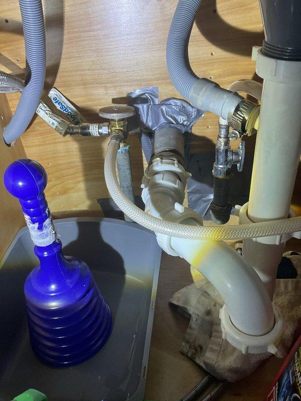 Responded to service call for corroded galvanized piping causing low water pressure at kitchen sink location. Upon inspection, assessed existing plumbing configuration including supply lines, drain assembly, and garbage disposal connections beneath sink. Documented current condition of water supply system, noting deteriorated galvanized piping requiring replacement. Photographed accessible plumbing components and provided estimate for pipe replacement to restore proper water pressure and system functionality.