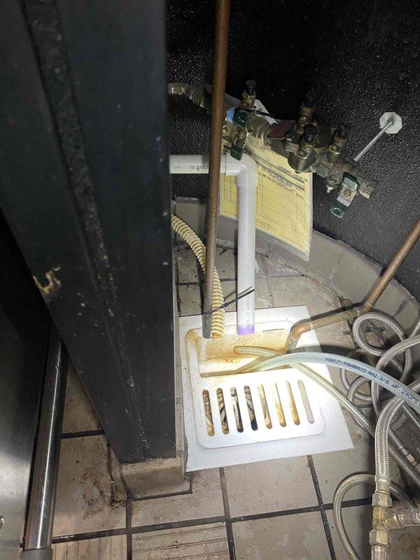Replaced existing drain assembly with new PVC piping and proper trap configuration beneath sink fixture. Installed white PVC P-trap assembly with appropriate threaded fittings and connections, including blue gasket seal to ensure watertight operation. All components were secured with proper PVC connections per code requirements to restore functional drainage system.
