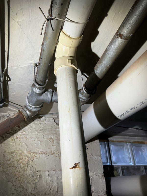 Completed comprehensive assessment of residential sewer and plumbing systems requiring multiple repairs and upgrades. Evaluated 7-foot section of compromised sewer line near main connection for repair, identified location for external cleanout installation, and assessed feasibility of trenchless sewer line lining from property to main. Inspected aging galvanized water supply piping throughout structure requiring replacement with modern materials, along with failed main water shut-off valve needing immediate replacement. Provided rough-in plumbing specifications for planned basement bathroom installation and future laundry room addition. Assessed existing water heater condition for potential replacement and identified locations for additional interior shut-off valves to improve system isolation capabilities. Documented existing plumbing infrastructure including mixed PVC and galvanized piping configurations, copper supply lines, and water meter assembly showing signs of age and previous