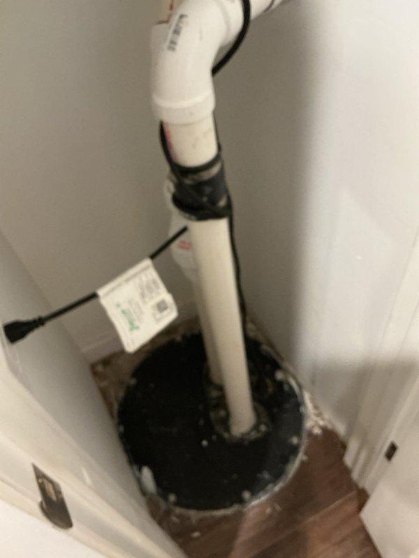 Responded to service call regarding intermittent rotten egg odor emanating from recently installed sump pump system located in nursery. Conducted thorough inspection of sump pump installation, basin seal integrity, and discharge piping system. Examined vertical PVC discharge line with mounting brackets, basin cover seal, and check valve operation to identify potential sources of sulfur smell. Inspected exterior discharge point and observed significant corrosion on metal components at grade-level termination point. Verified proper trap configuration and ventilation to prevent sewer gas backflow into living space. Assessed basin for standing water conditions that could promote anaerobic bacterial growth causing hydrogen sulfide odor. Confirmed system operational functionality and seal integrity to ensure no safety hazards present for occupants.