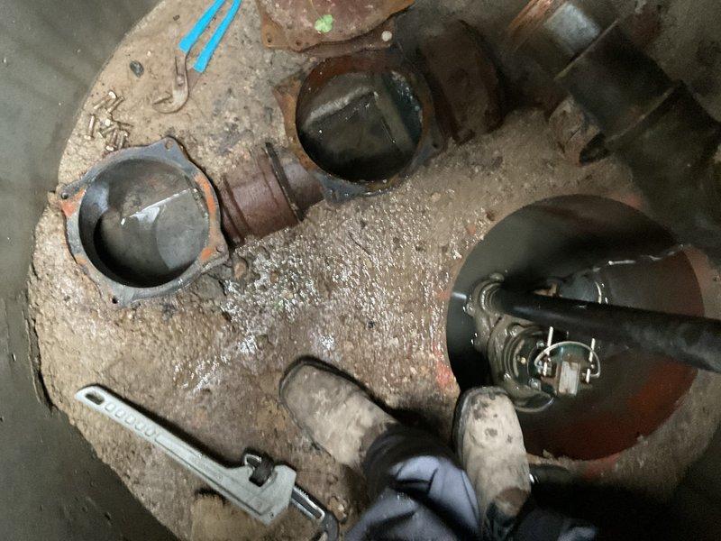 Completed comprehensive flood control and sump pump system inspection as requested. Accessed and inspected the concrete sump basin, which contained three check valve discharge points with accumulated sediment and standing water. Cleaned and evaluated the pit condition, noting mineral deposits and water exposure on concrete surfaces. Removed debris and sediment buildup from the basin floor to ensure proper drainage function. All check valves and discharge fittings were examined for proper operation and positioning within the system.