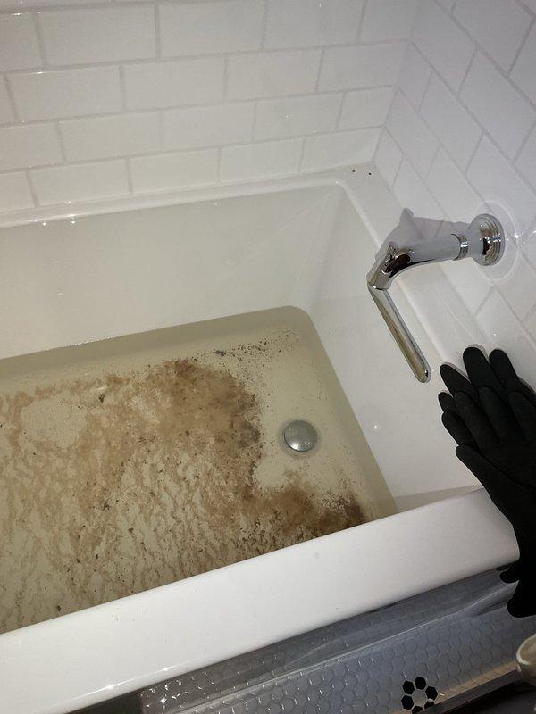 Responded to emergency main floor sewer line stoppage in 101-year-old residence where wastewater was backing up through bathtub and toilet. Cleared blockage from main sewer line, restoring proper drainage throughout plumbing system. Sediment and debris accumulation typical of aging cast iron piping was removed, and all fixtures were tested and confirmed operational upon completion.
