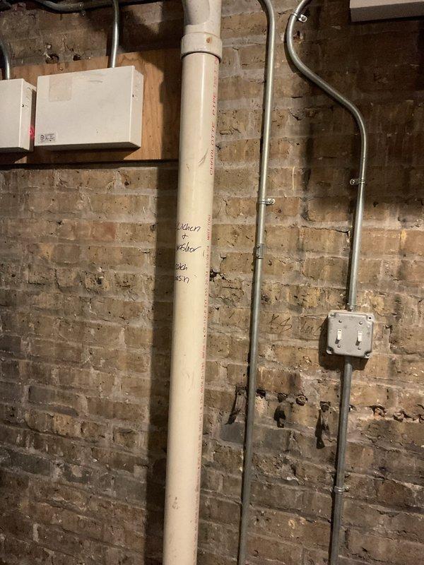 Completed comprehensive plumbing repair proposal with deferred payment structure tied to scheduled maintenance visits. Documented existing utility infrastructure including outdoor utility access point with concrete pad and service cover, along with interior basement plumbing system featuring vertical PVC drainage piping, electrical conduit routing, and junction boxes mounted to exposed brick wall. Down payment collected at time of sale, with remaining balance to be split across two future scheduled maintenance appointments in subsequent years.