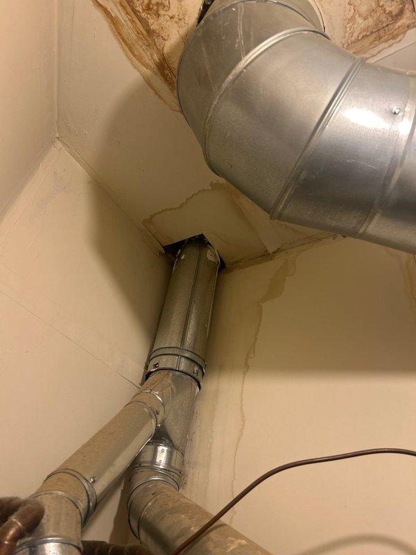 Conducted plumbing estimate for water heater replacement at residential property. Inspected existing 50-gallon water heater approximately 20 years old, which is currently operational but nearing end of service life. Documented existing installation in utility room, including copper and black pipe connections at top of unit, proximity to HVAC equipment, and overall configuration of mechanical space. Noted evidence of water staining on walls and ceiling near ductwork, indicating previous or ongoing moisture intrusion issues that should be addressed during replacement. Photographed current water heater setup, utility room layout, and surrounding plumbing connections to prepare accurate replacement estimate for new homeowners seeking proactive equipment upgrade.