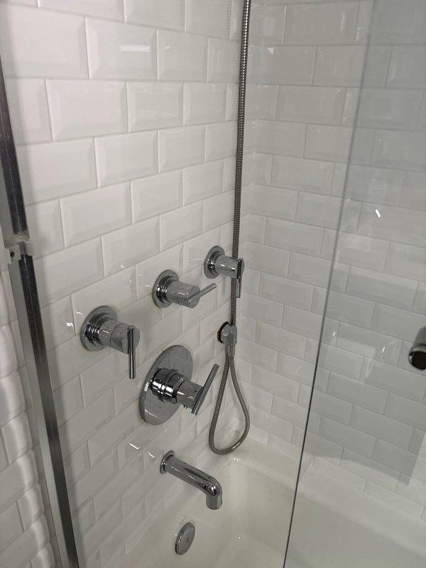 Responded to morning appointment for shower cartridge replacement. Upon inspection, found existing valve assembly with brass components showing age-related wear and mineral deposits. Successfully removed old cartridge from wall-mounted shower/tub control valve, replaced with new cartridge, and reassembled chrome fixtures including temperature control handles and diverter valves. Verified proper water flow and temperature control operation through handheld shower attachment and tub spout. System tested and restored to full functionality.