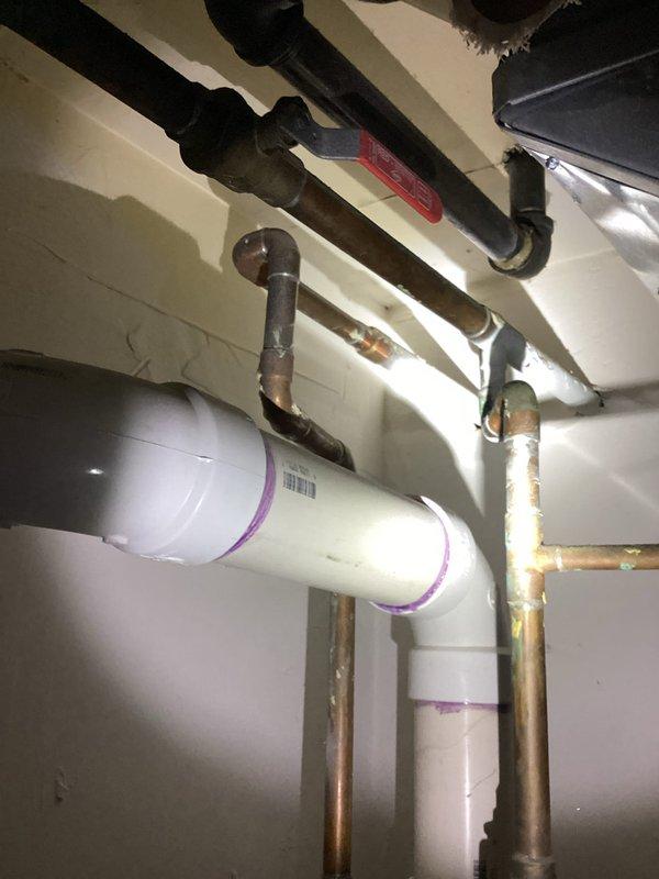 Responded to service call regarding ejector pump malfunction installed approximately one year prior. Customer reported multiple toilets backing up with water and moisture observed around pump pit area. Upon arrival, conducted thorough inspection of ejector pump system and associated plumbing connections in basement utility area. Examined PVC discharge piping with purple primer markings, copper supply lines, and pump pit condition. Assessed pump operation, float switch functionality, and check valve performance. Verified electrical connections and tested pump cycling. Inspected discharge line routing through ceiling area and confirmed proper venting configuration. Identified cause of system malfunction and moisture accumulation around pit. Performed necessary adjustments and repairs to restore proper ejector pump operation and resolve toilet backup issues.