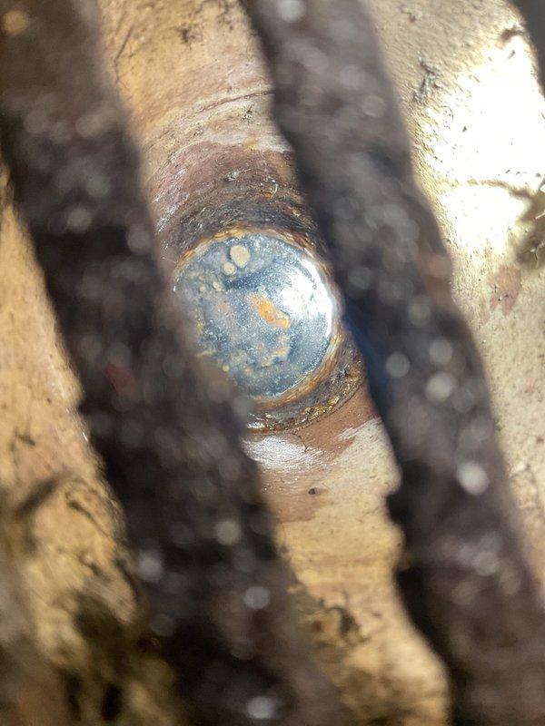 Completed plumbing inspection revealing aged copper piping system with significant corrosion and verdigris buildup at connection joints, along with assessment of dual vertical PVC drainage pipes equipped with rubber couplings and sensor cables. Documented existing conditions and scheduled installation work to address system concerns.