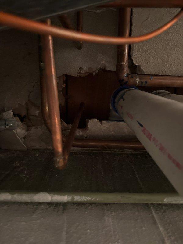 Responded to emergency plumbing call for outdoor spigot that would not shut off, an issue that had persisted since the previous fall season. Upon inspection of the 60-year-old home's plumbing system, accessed the utility area and crawl space to assess the water supply lines feeding the exterior fixture. Found aging copper piping with corroded mounting brackets and evidence of mineral deposits throughout the plumbing assembly, indicating long-term water quality issues and component deterioration. Shut off water supply to the affected spigot line and removed the failed outdoor fixture. Replaced the defective outdoor spigot with new frost-proof sillcock assembly, ensuring proper installation depth and pitch to prevent future freeze damage. Installed new mounting hardware and verified secure attachment to exterior wall structure. Restored water supply and tested new spigot through multiple open/close cycles to confirm proper shut-off function and verify no leaks at connection points or val