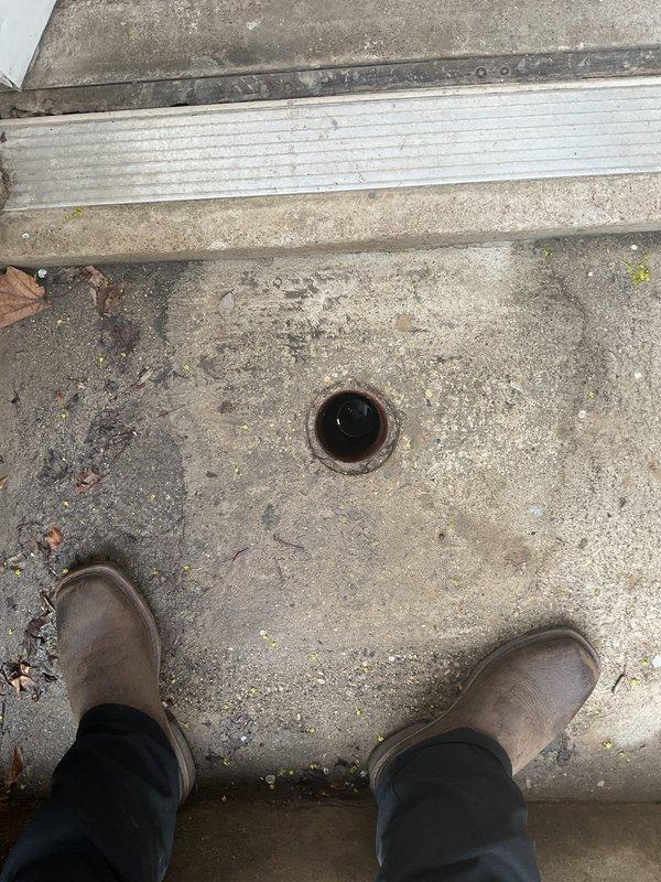 Responded to a main drain cleanout at a century-old residential property where the outdoor drain system had been completely blocked for one month due to a collapsed drain line. Accessed the exterior drain opening located at the below-grade entrance landing, assessed the blockage condition, and documented the deteriorated drainage infrastructure. Due to the structural collapse of the aging drain pipe, recommended full drain line replacement to restore proper function to the main sewer system.