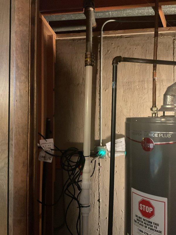 Responded to water leak locate service call at residential property. Upon arrival, inspected utility area containing water heating system and associated plumbing infrastructure. Conducted thorough visual examination of Rheem Performance Plus water heater installation, including all connected piping, fittings, and valves. Inspected black metal supply lines, white PVC drainage system, and brass connection points for signs of moisture, corrosion, or active leaking. Examined teal-colored valve assembly and surrounding pipe connections for potential leak sources. Checked water heater tank exterior for condensation or water stains that might indicate internal tank failure or connection leaks. Evaluated condition of pipe joints, threaded connections, and compression fittings throughout the system. Documented equipment conditions and plumbing configuration with photographs for service records. All accessible plumbing components in mechanical room were visually assessed as part of comprehensive