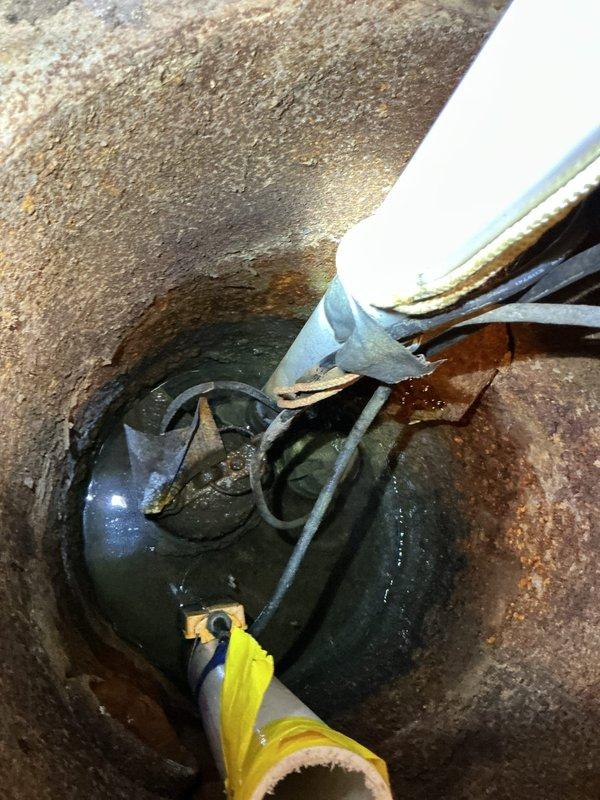 Responded to service call for sump pump running continuously with grinding noise. Upon inspection, found 15-year-old sump pump in basement utility area showing signs of mechanical failure. Pump motor exhibited grinding sounds indicative of bearing wear and impeller damage common in units of this age. Float switch mechanism was operational, but pump failed to cycle off properly due to internal component deterioration. Standing water in sump basin confirmed pump was no longer effectively evacuating water. Documented existing installation showing pump positioned in concrete basin with PVC discharge piping and electrical connections. Advised customer that pump had reached end of serviceable life and recommended replacement to prevent potential flooding risk and restore proper basement water management system functionality.