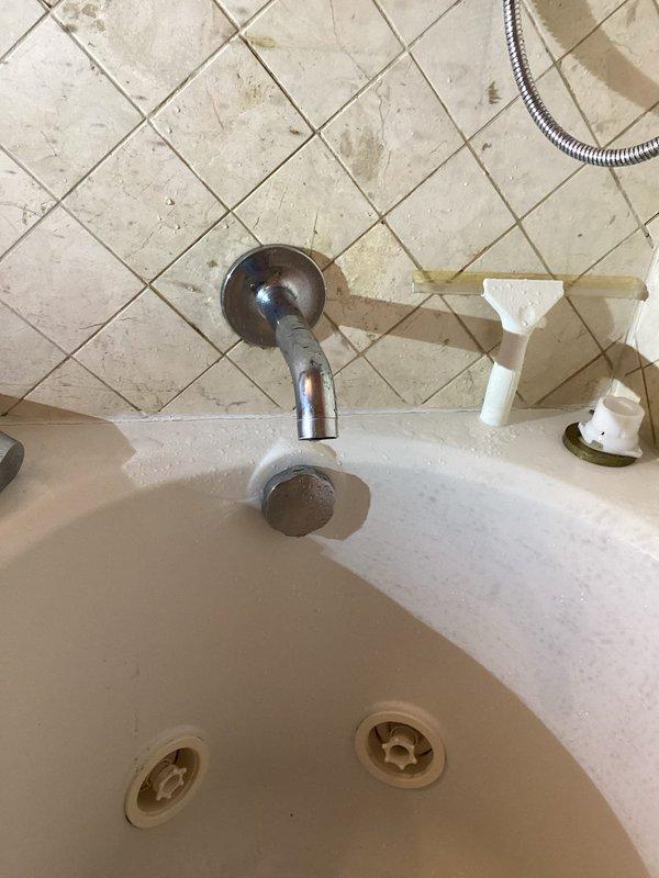 Replaced defective bathtub diverter valve assembly and cartridge in residential bathroom. Building water supply was shut down from 9AM-1PM to facilitate safe removal and installation of plumbing components, ensuring no water damage or service interruption to occupied units during the repair.