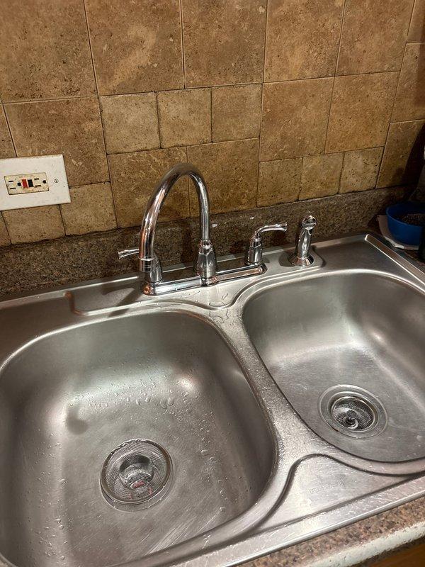 Responded to service call for leaking faucets in both bathroom and kitchen sink locations. Inspected kitchen double-basin stainless steel sink with chrome high-arc faucet and side sprayer assembly, identifying source of leak and performing necessary repairs to restore proper function and eliminate water waste. Addressed bathroom shower valve fixture with chrome finish, resolving leak issue at the valve assembly. Both fixtures were tested for proper operation and confirmed to be functioning without leaks upon completion of repairs.