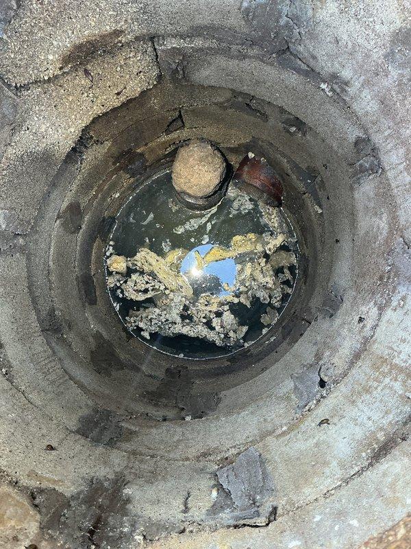 Conducted site evaluation for standpipe installation in 70-year-old residence experiencing recurring basement flooding issues. Assessed existing floor drain with significant sediment buildup and standing water, documented drainage infrastructure condition, and evaluated two PVC pipe penetrations in tiled floor area to determine optimal standpipe placement and drainage solution for flood prevention.