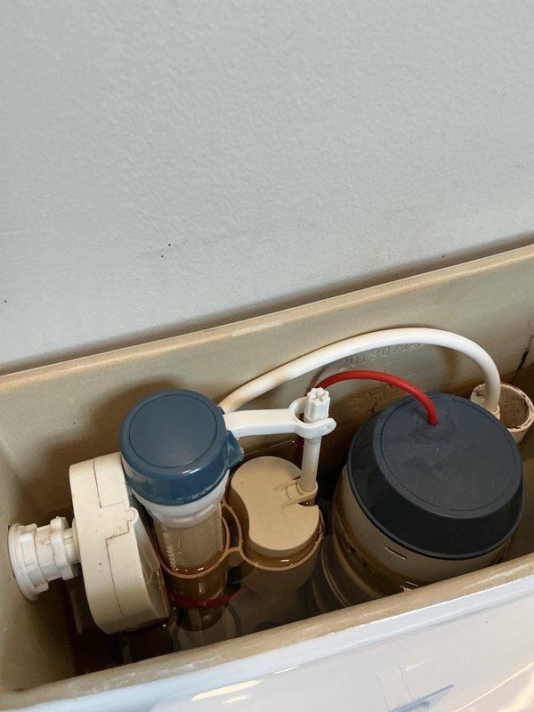 Responded to report of toilet leaking from tank connection point. Upon inspection, identified leak originating from compromised tank-to-bowl mounting hardware at right rear position. Removed toilet tank lid to assess internal components and verify no additional issues with fill valve, flush valve, or associated mechanisms. All internal components including fill valve assembly, overflow tube, and flush valve were found to be in normal operating condition. Tightened tank mounting bolt and coupling nut at affected location to restore proper seal and eliminate active leak. Verified repair by checking for moisture and confirming secure connection at all tank mounting points.
