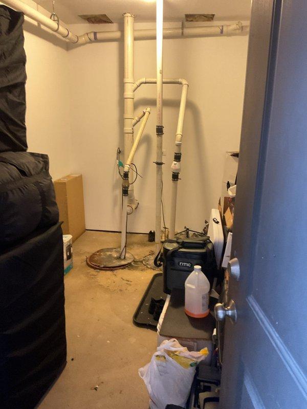 Conducted on-site assessment of residential sewer system to provide rodding estimate. Inspected basement plumbing configuration including multiple vertical PVC drain stacks with various fittings, couplings, and connections. Evaluated existing pipe conditions, noting older weathered sections and newer installations with rubber couplings. Documented floor drain access point and pipe penetrations through concrete foundation for potential cleaning access. Photographed complete plumbing layout to support estimate preparation for main line rodding services.