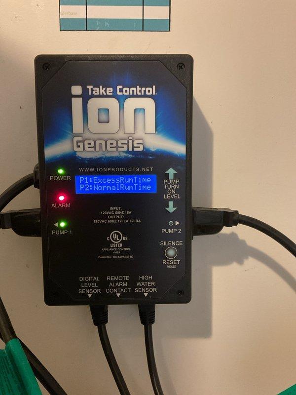 Responded to service call for battery pricing inquiry on sump pump backup system. Inspected and photographed Ion Genesis Take Control dual pump control unit showing P1 excess runtime alarm and illuminated alarm indicator, suggesting primary pump operational issues. Documented backup battery power supply unit with dual cooling fans in operational condition. System requires battery replacement to maintain emergency backup functionality during power outages.