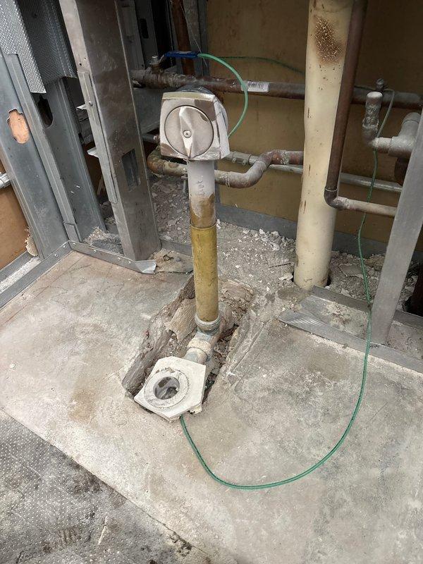 Installed shower pan in commercial building during scheduled facility shutdown. Completed rough plumbing connections to existing drain line and secured flange assembly to concrete floor in preparation for final shower installation. Building water systems were temporarily shut down to facilitate safe installation of the new shower pan assembly.