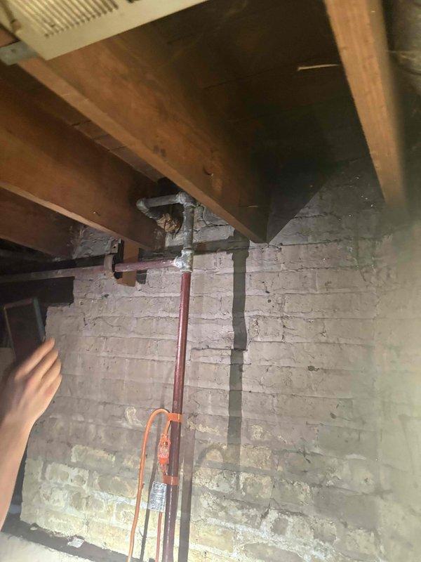 Conducted on-site assessment of existing plumbing system and sump pump installation in basement area. Inspected deteriorated foundation walls showing moisture infiltration, mold growth, and structural concerns that may impact plumbing modifications. Documented current pipe routing including vertical discharge lines and existing utility connections mounted to floor joists. Reviewed architectural floor plans to determine optimal placement for proposed plumbing changes and sump pump relocation. Provided comprehensive estimate for replacing existing plumbing infrastructure and sump pump system based on site conditions and customer requirements.