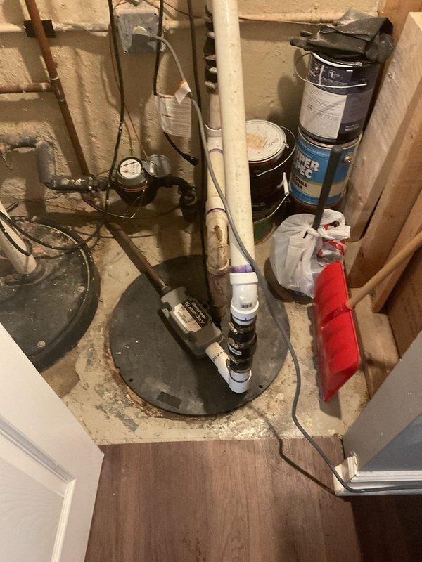 Responded to morning appointment for sump pump evaluation in basement utility area. Upon inspection, assessed existing sump pump system including basin, discharge piping, and electrical connections in unfinished basement space with exposed mechanical systems. Documented current installation configuration with white PVC discharge pipe and power supply setup. Provided comprehensive estimate for VIP sump pump replacement including removal of existing unit, installation of new pump system, and proper integration with existing plumbing infrastructure and electrical components.