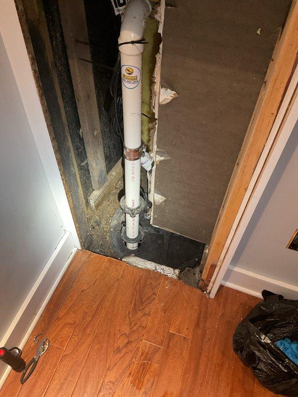 Responded to emergency service call for failed ejector pump system resulting in basement flooding. Upon arrival, assessed the VIP ejector pump previously installed at the property and confirmed complete system failure. Removed defective pump unit from pit, which contained standing water with debris accumulation. Inspected existing PVC discharge piping running vertically through wall cavity and verified proper routing and connections. Cleared flooded area and extracted standing water from pump basin. Installed replacement ejector pump assembly, reconnected to existing 2-inch PVC discharge line, and tested system operation under load conditions. Verified proper float switch activation, pump cycling, and discharge flow. Also conducted preliminary inspection of water heater per customer request and identified operational issues requiring attention. System restored to full functionality with no leaks detected at connections or discharge points.