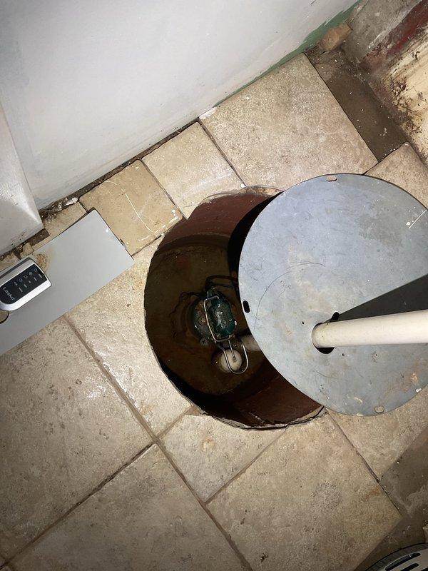Responded to emergency service call for failed ejector pump system resulting in basement flooding. Upon arrival, assessed the VIP ejector pump previously installed at the property and confirmed complete system failure. Removed defective pump unit from pit, which contained standing water with debris accumulation. Inspected existing PVC discharge piping running vertically through wall cavity and verified proper routing and connections. Cleared flooded area and extracted standing water from pump basin. Installed replacement ejector pump assembly, reconnected to existing 2-inch PVC discharge line, and tested system operation under load conditions. Verified proper float switch activation, pump cycling, and discharge flow. Also conducted preliminary inspection of water heater per customer request and identified operational issues requiring attention. System restored to full functionality with no leaks detected at connections or discharge points.