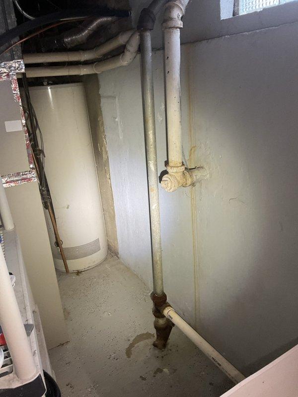 Responded to emergency flooding situation in basement. Conducted thorough inspection of sewer system and sump pump assembly to document conditions for insurance claim purposes. Assessed utility room plumbing infrastructure including water heater installation, vertical drainage piping, and associated brass fittings showing age-related wear and corrosion. Examined sump pump discharge line routing through crawl space, noting flexible duct installation secured with mounting straps. Documented water damage evidence on concrete flooring and wall surfaces. Photographed all relevant plumbing components, drainage systems, and areas affected by water intrusion to provide comprehensive visual documentation for insurance assessment.