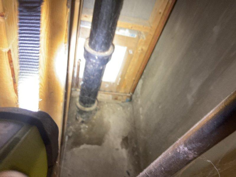 Responded to emergency flooding situation in basement. Conducted thorough inspection of sewer system and sump pump assembly to document conditions for insurance claim purposes. Assessed utility room plumbing infrastructure including water heater installation, vertical drainage piping, and associated brass fittings showing age-related wear and corrosion. Examined sump pump discharge line routing through crawl space, noting flexible duct installation secured with mounting straps. Documented water damage evidence on concrete flooring and wall surfaces. Photographed all relevant plumbing components, drainage systems, and areas affected by water intrusion to provide comprehensive visual documentation for insurance assessment.