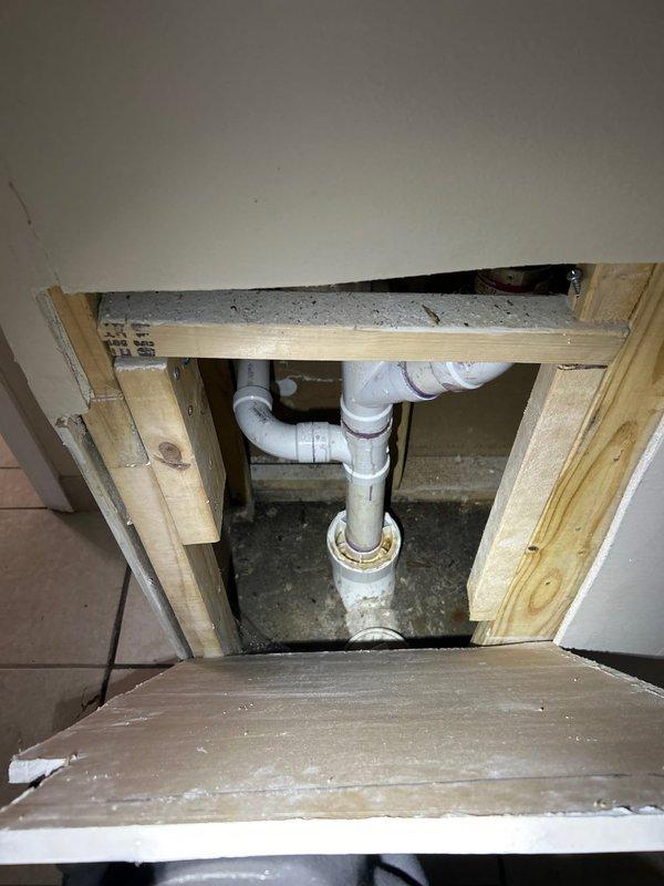 Responded to service call for malfunctioning sump pump system. Upon inspection, assessed sump pump installation including discharge piping configuration running from interior pit through exterior of residence. Verified PVC discharge line routing from basement/crawl space access point, through floor penetration, and out to exterior drainage termination point along side of building. Inspected pump chamber accessibility through floor-mounted access opening, confirmed proper pit construction and plumbing connections including vertical discharge pipe with appropriate fittings and floor flange assembly. Evaluated exterior discharge line installation including proper slope and termination away from foundation. System restored to proper working condition.