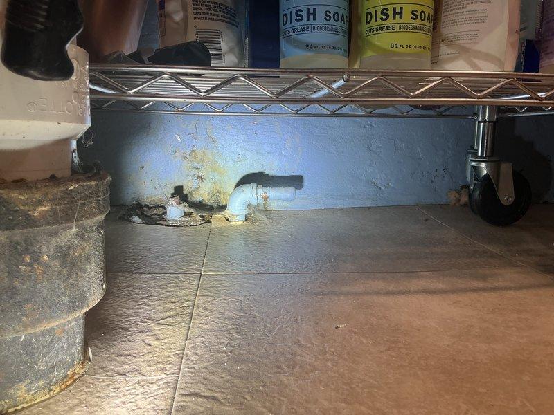 Performed comprehensive camera inspection of main sewer line and ejector pit system to assess disconnection issues in basement area. Inspection revealed need for excavation work to properly reconnect main sewer line to ejector pit, with documentation provided through photographic evidence of affected utility areas including basement storage space and adjacent bathroom facilities.
