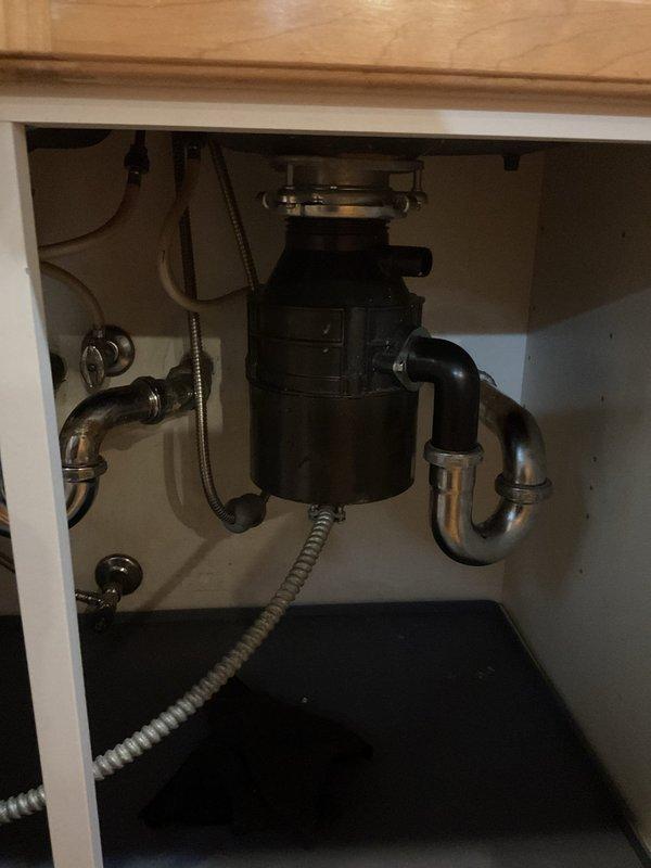 Responded to service call for garbage disposal backup affecting multiple units. Upon inspection, found disposal unit draining improperly, causing wastewater to back up into neighboring sink. Assessed under-sink plumbing configuration including P-trap assembly and drainage connections. Cleared blockage from disposal unit and verified proper drainage flow through shared waste line. Tested system operation to ensure complete resolution with no cross-contamination between units.