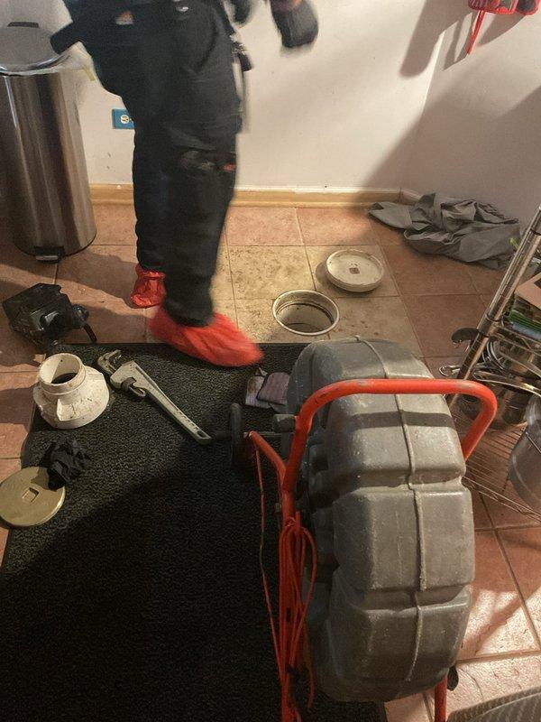 Responded to clogged drain service call and accessed main sewer line through floor cleanout. Deployed professional drain cleaning machine with cable to clear obstruction in main line. Successfully restored proper drainage and flow to affected fixtures, verified system operation, and left premises clean with all equipment properly stowed.
