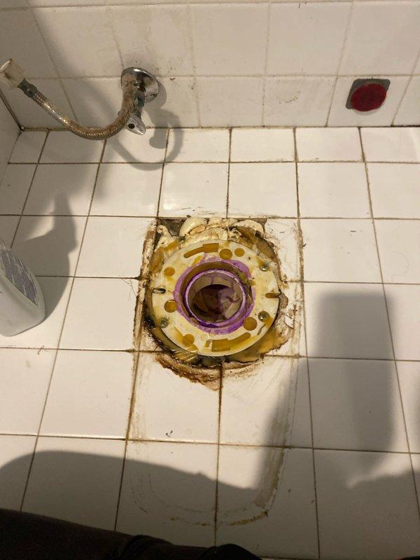 Completed toilet installation in residential bathroom with white tile flooring and walls. Removed existing toilet fixture that showed significant water damage and brown staining around the floor flange area, indicating previous leakage or seal failure. Installed new wax ring seal and properly seated toilet on flange to prevent future water seepage. Connected water supply line and tested for proper flush operation and leak-free performance.