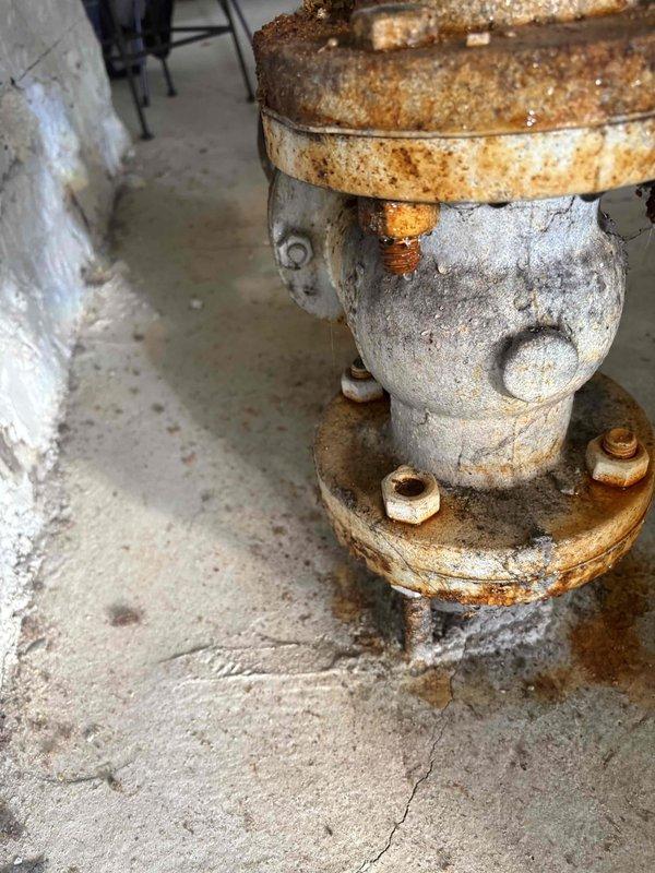 Conducted site inspection of main water shutoff valve and 3-inch valve/nipple assembly at 12-unit condominium building as flagged by City Water Department. Assessed heavily corroded main shutoff valve, flanged pipe fittings, and associated piping components showing extensive rust deterioration and oxidation throughout the assembly. Documented condition of bronze water meter, corroded valve body with flanged connections, and deteriorated bolted flanges requiring replacement to meet municipal requirements. Provided comprehensive estimate for replacement of 3-inch valve assembly and coordination with City Water Department for completion of their work.