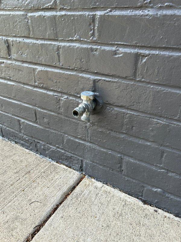 Responded to report of leaking outdoor spigot with water supply shut off. Upon arrival, inspected exterior hose bib mounted on painted brick wall and identified source of leak. Replaced faulty spigot assembly with new frost-proof hose bib, ensuring proper seating against masonry and secure mounting. Restored water supply and tested fixture under full pressure to verify leak was eliminated and proper operation of shutoff valve. No additional leaks detected at connection points or through wall penetration.