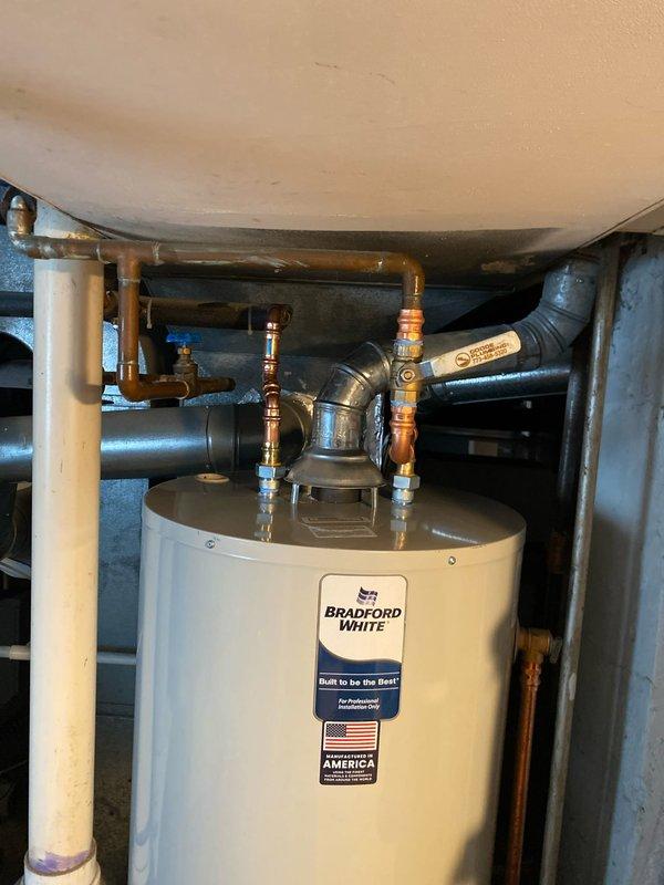 Responded to emergency no hot water call and performed same-day water heater replacement. Removed existing failed unit and installed new Bradford White residential water heater in crawlspace utility area. Connected all copper supply lines, installed brass shut-off valves on inlet and outlet connections, and integrated flexible water lines with proper fittings. Verified all plumbing connections for proper operation, tested unit functionality, and restored hot water service to the residence.